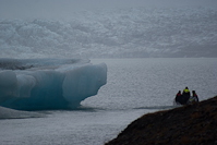 two tourists and a guide head across Jökulsárlón towards the glacier Breiðamerkurjökull